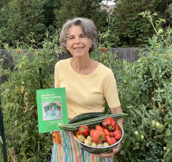 Linda in her garden with her cookbook, "Garden to Table Cooking"