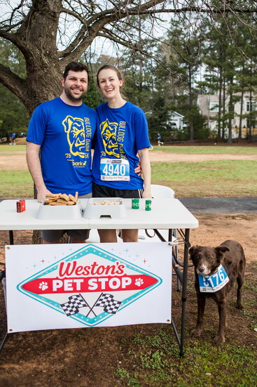 Thomas and Kaylee stand with their dog, June Bug, at the 2026 Bulldog Dash 5K at Weston's Pet Stop.