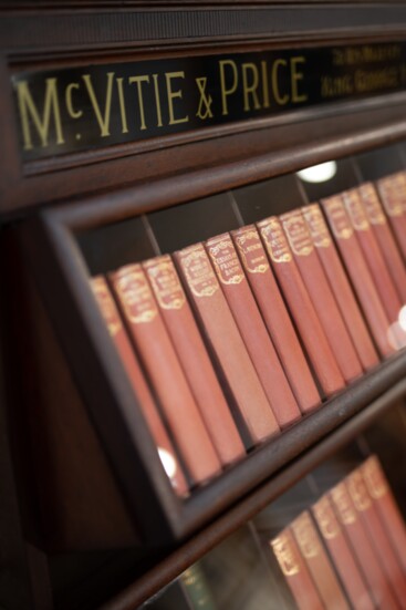 An antique British biscuit display is repurposed as a bookshelf