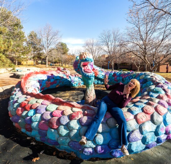 Mayor Lauren Simpson enjoys a moment with Arvada Center for the Arts and Humanities’ Squiggles the Serpent playground sculpture.