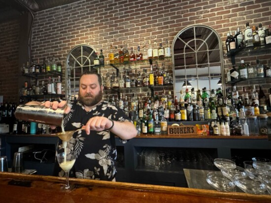 Bartender Dallas J. Sweecy pouring a cocktail