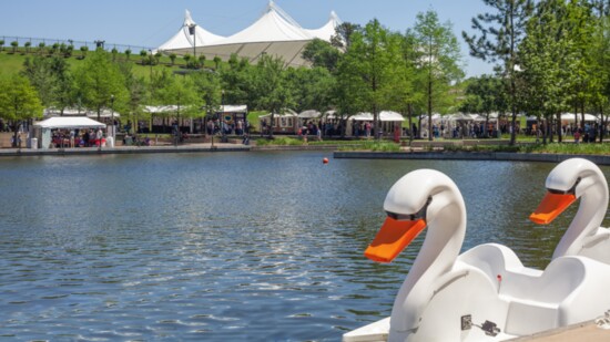 A view of the Swan Rides with artist booths across the Waterway. Photo courtesy visitthewoodlands.com.