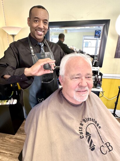 Anthony McLemore working in his barbershop with client Scott Henderson