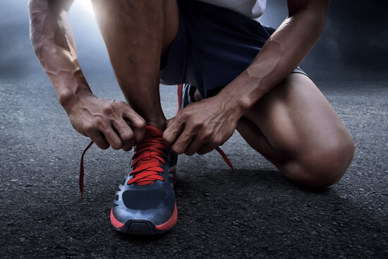 Man lacing up sneakers.