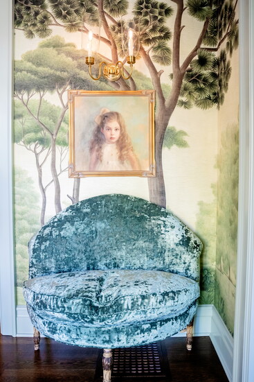 Scenic mural wallpaper by Iksel for Schumacher wraps the walls of the entry hall, where a vintage velvet settee sits beneath a Teresa Mattos portrait of the