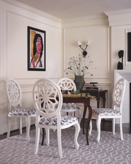 A vintage game table and chairs sourced on Chairish.com sit atop an Ellipse rug by Stark Carpet. 