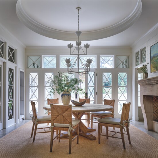 The dining room features beautiful natural light and architectural detail, which designer Ashley Shaw augmented with a chandelier from Julie Neill’s Visual 
