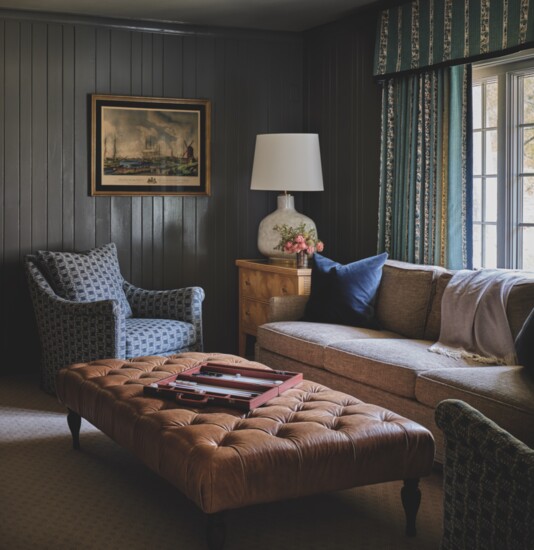 A Charles Stewart Timberline Sofa is flanked by a pair of Hickory Chair Armchairs upholstered in Colefax & Fowler geometric fabric in this cozy family den. 