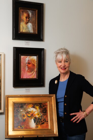 Susan Hotard with her portrait and floral still life paintings