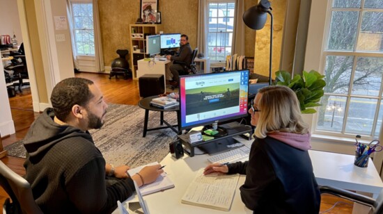 Silas Tibbs, Ryan Heitkamp + Melissa Bertram work upstairs in an open floor plan office space. 