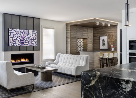 A corner bar replete with wine storage, ice maker, beverage cooler, sink and more, is centered around a mosaic tile backsplash of polished marbles and stones.