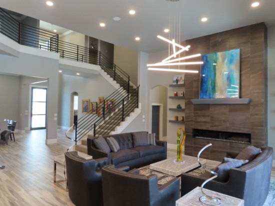 The Living room fireplace rises to the 14-foot ceiling while a spiral floating light fixture takes center stage. 