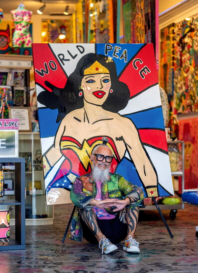 TAVi seated in front of his paintings, "World Peace" (48" x 60").