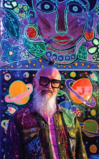 TAVi stands in front of two of his pieces, "Alien in the Universe" (bottom, 48" x 60") and "Frida in the Garden" (48" x 60"), recently sold to an LA collector.