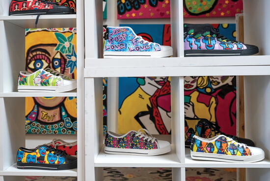 Hand-painted merchandise like these sneakers make TAVi's colorful art accessible and wearable for collectors of all budgets.