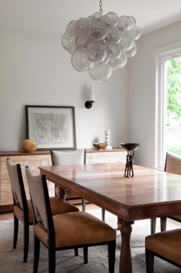 The light in the dining room is the Muriel Cloud Chandelier by Oly Studio.