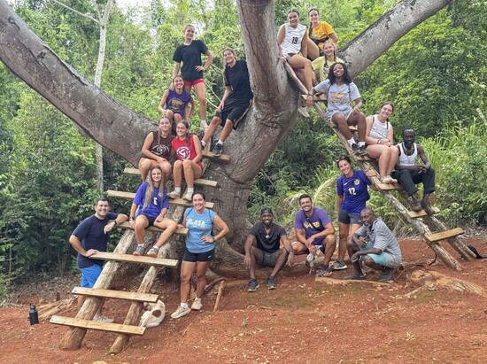 Team members with Ryan Campbell, Ganga, and Stick Man at the top of a mountain on the last day in Harmons.