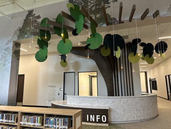 A tree hovers over the Children’s Department information desk.