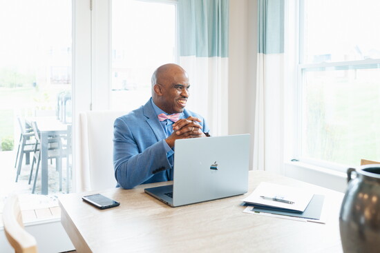 Barry Bates prepares to assist clients with their home search, seated in a model home that reflects the kind of personalized spaces he helps buyers find.