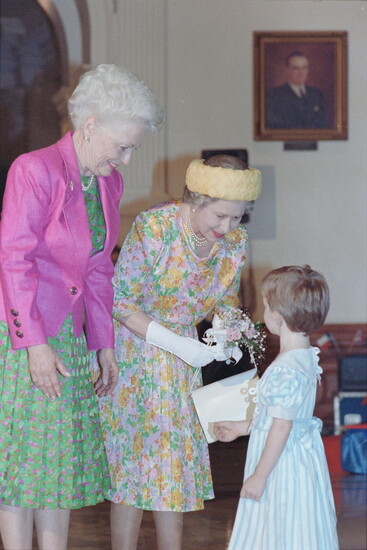 The late Texas governor, Ann Richards and Queen Elizabeth II interacting with a young child. 