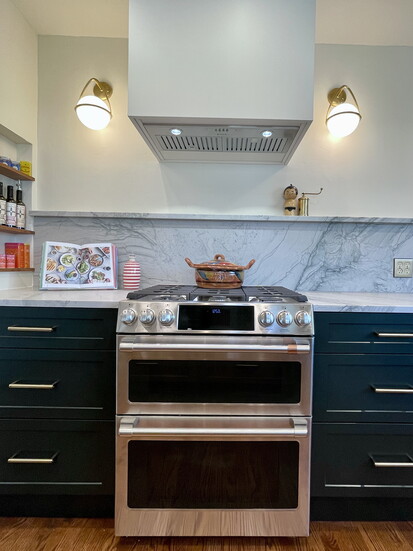 A full quartz backsplash presents a seamless background while the wall cubby provides a home for oils and spices, freeing up countertop space. 