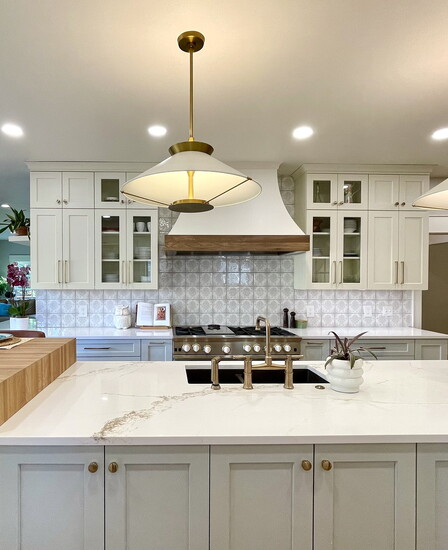 Handmade Spanish tile, pale blue base cabinets, and a custom walnut bar top stand out in this family kitchen.