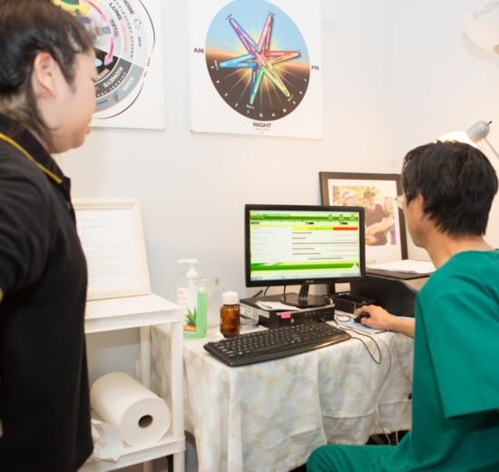 Lighter Chen shows a client their qi analysis then discusses their plan for treatment. 