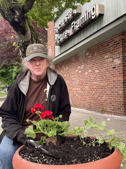 Resident Theresa Paige maintains flower pots near her E. Main St. home