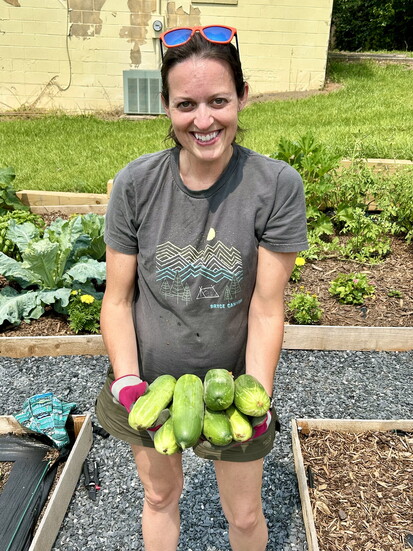 Tiffany Koehn smiles with her fresh harvest of cucumbers, ready to share with friends.