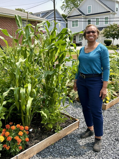 Elaine Eaton's corn is nearly as tall as she is—truly a sweet summer success!