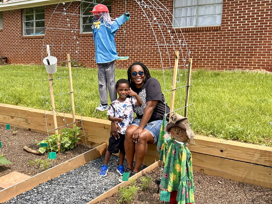 LaVaon Martin and young Dax show off the scarecrows he and his sister, Nadia, made.