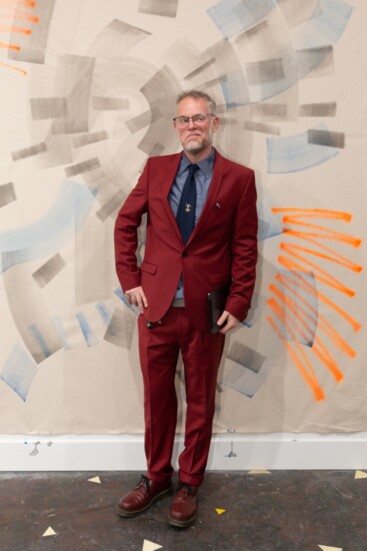 Curator Dan Bailey with artwork by Anna Kolosova at The Old Bailey Gallery, October  2023. Photo by Yoon Kim