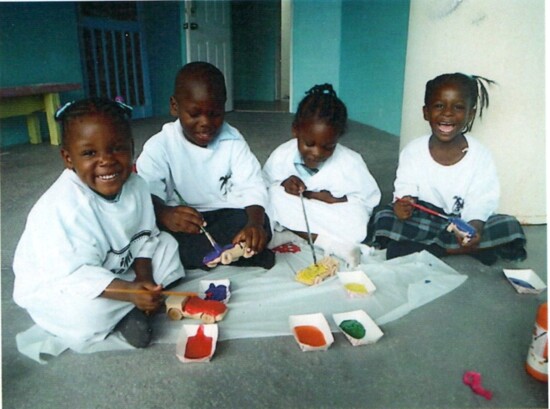 Children in Haiti painting their new wooden toys.