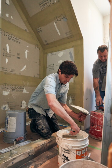 Christopher Kubik of Kubik House preps the space for placement of the porcelain panels.