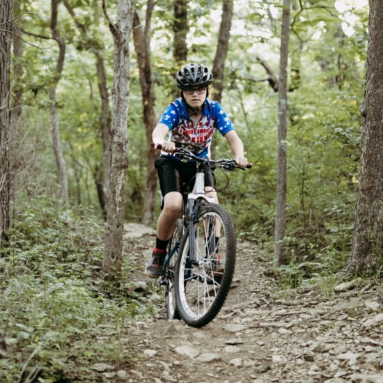 Xander Elwell bikes through a trail at Hodge Park.