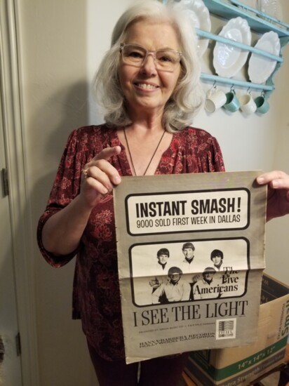 Carla Rabon displays a poster advertising The Five Americans' 1966 single "I See The Light."