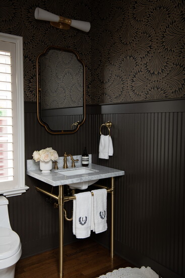 Grasso transformed the powder room with Anthropologie wallpaper and Sherwin-Williams Black Fox paneling