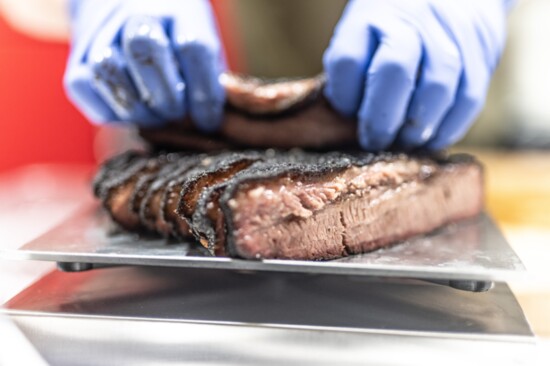 Tender slices of brisket are prepared for a to-go order