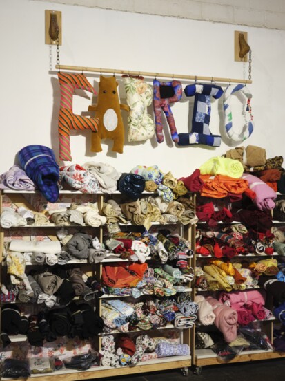 Fabric wall where customers can choose from a selection of color organized fabrics.