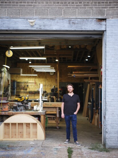 Chris Scott, Founder and Director of Operations, poses outside the wood shop.