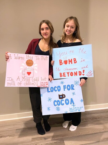 Charlotte Russell (right) and a fellow student display signs promoting mental health awareness and wellness initiatives at Cranbrook Schools. 