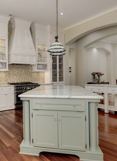 Catering kitchen with marble island and glass front cabinetry