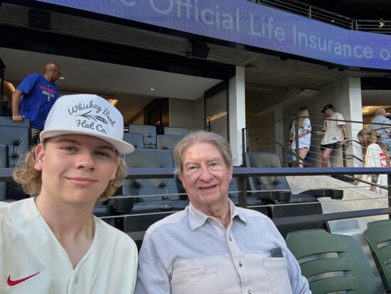 Mike watching a game with grandson Colin Moore.