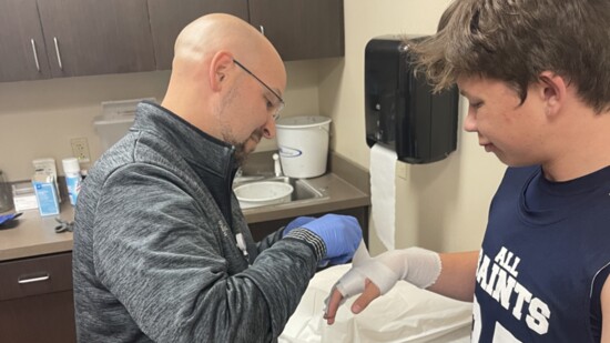 Michael Crawford, PA-C, treats 14-year-old Rylan Kuklinksi for a dislocated pinky suffered while playing basketball at the new Ortho Stat clinic.