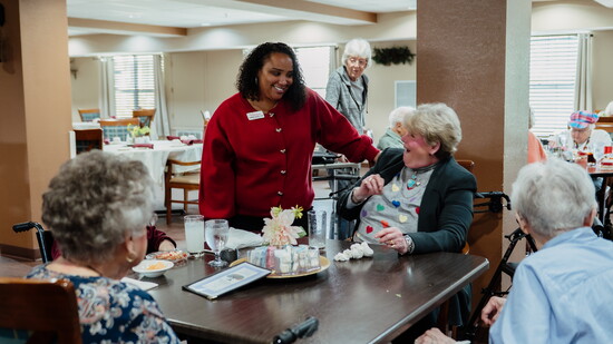 Jasmine Banks with residents in Tradition's dining room.