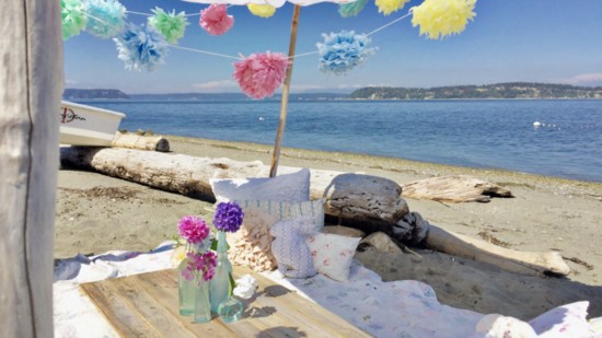A sandy spot on the beach in the midst of driftwood logs is the perfect setting for a bohemian picnic. Add a sheet draped between driftwood poles and some color