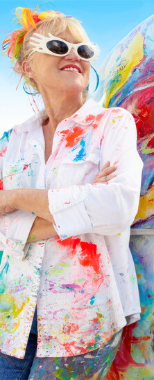 Leoma Lovegrove leans against painted camper.