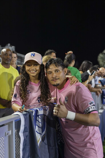 Captain and Goalkeeper, Edward "Lalo" Delgado with a fan after a game. 