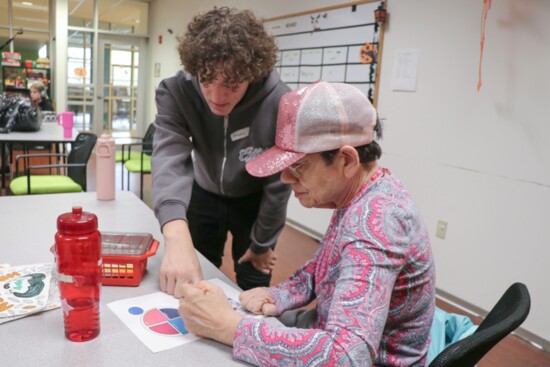 A volunteer assists in Adult Day Services with an activity on making healthy choices.