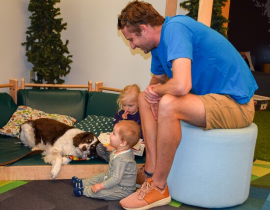 PAWS Therapy Dog Lucky brings smiles and snuggles as a dad shares storytime with his children.